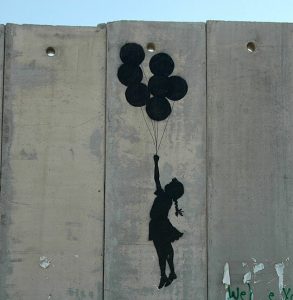 niña volando con globos de Banksy